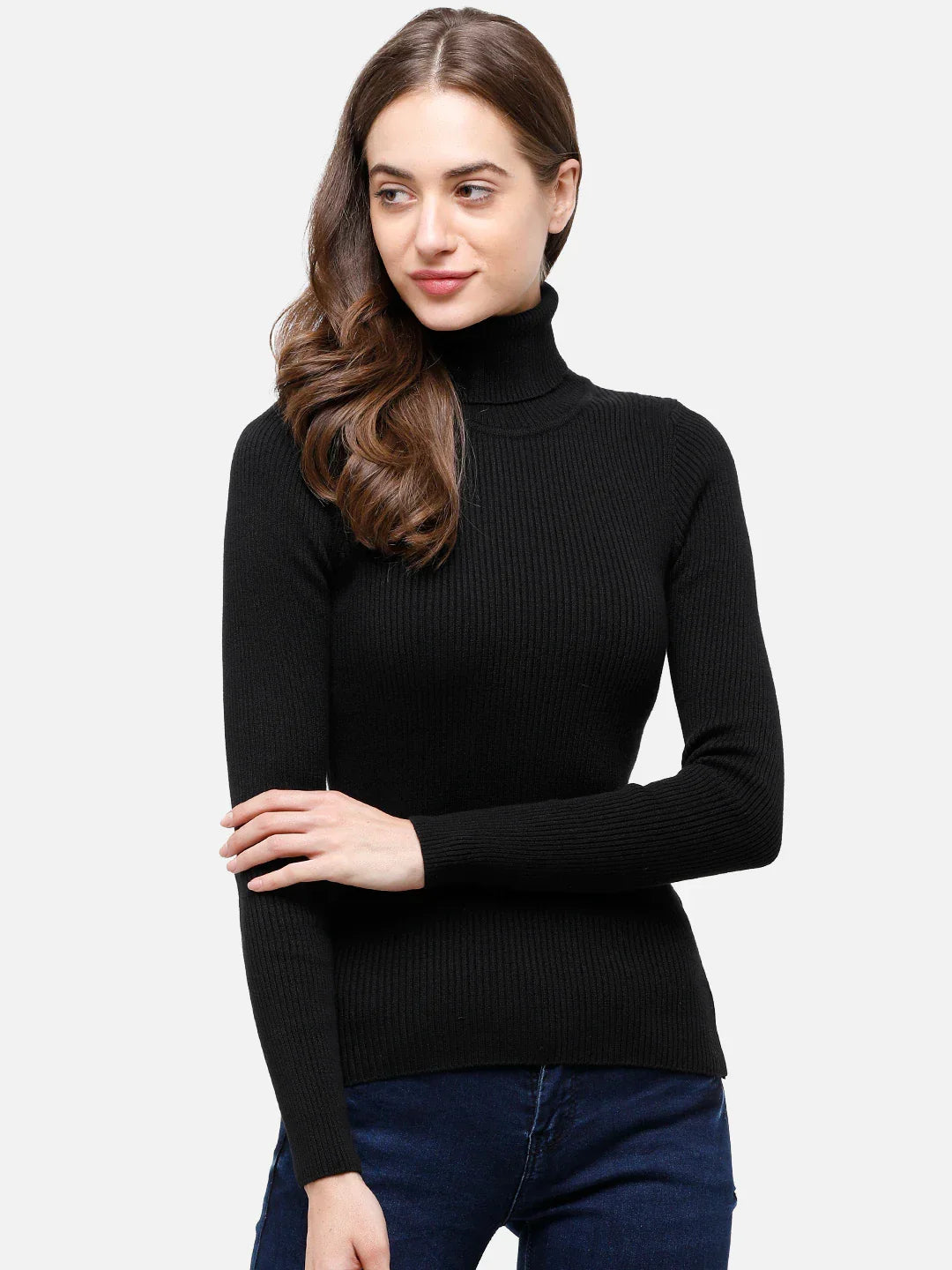 Woman in a 98degreenorth black ribbed turtleneck sweater and blue jeans, standing against a plain background.