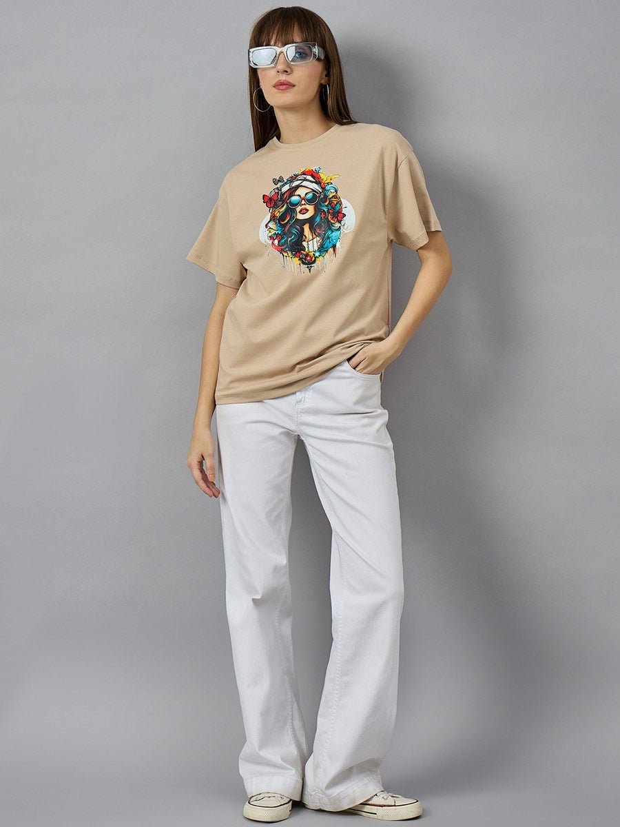 Woman in sunglasses wears 98degreenorth Casual Cotton Typography T-shirt, white pants, and shoes against a gray background.