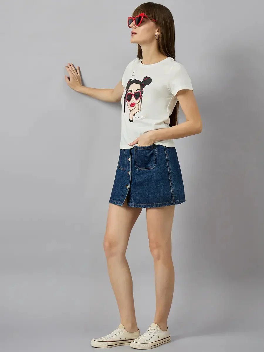 Woman in 98degreenorth cotton typography t-shirt with relaxed streetwear vibe, denim skirt, and white sneakers.