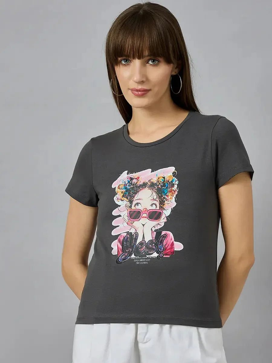 Woman wears a 98degreenorth classic round-neck cotton typography t-shirt with white pants, against a gray background.