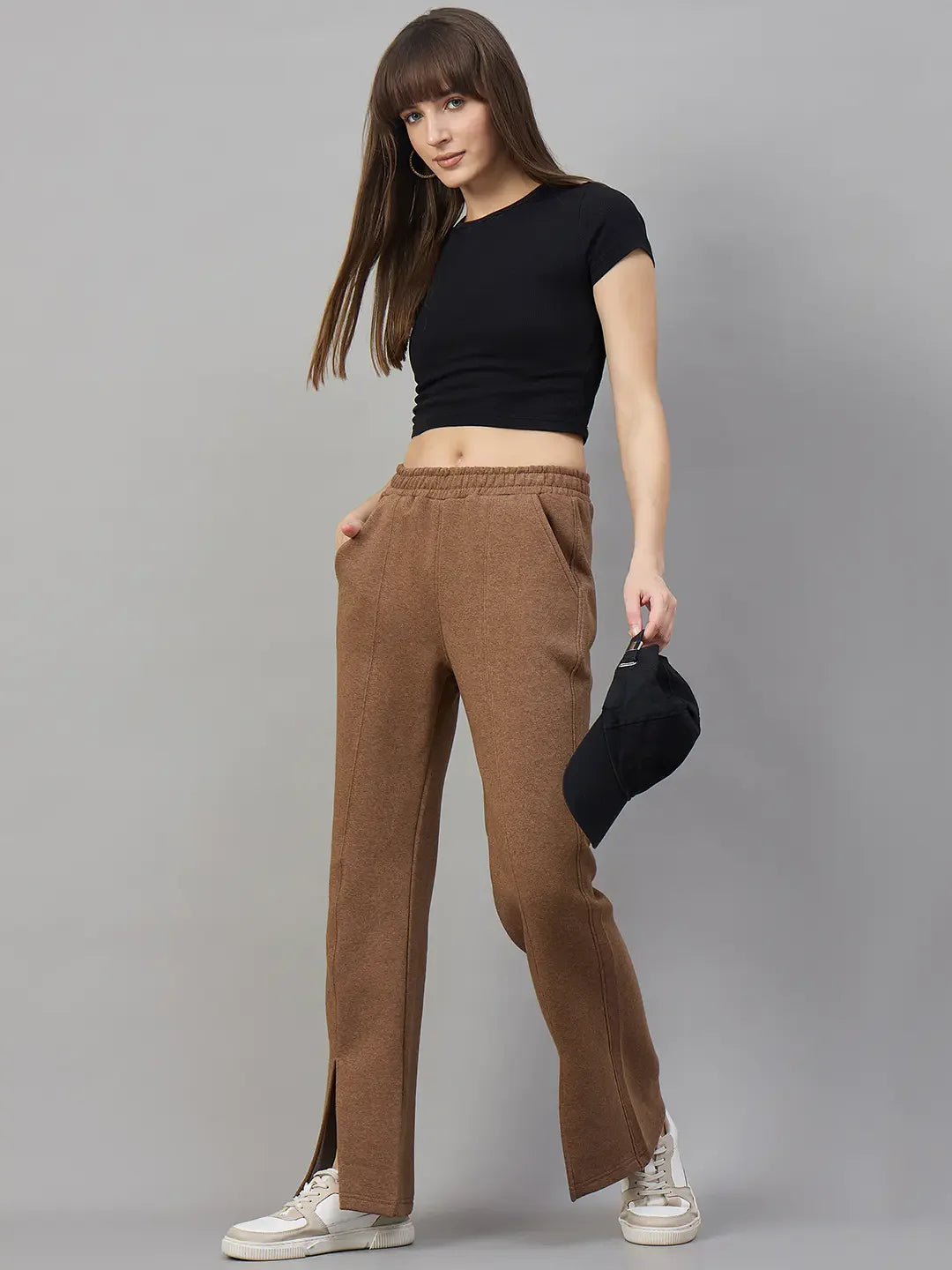 Woman in a black crop top and 98degreenorth Coffee Melange Women’s Fleece Bootcut Sweatpants stands by a gray backdrop.
