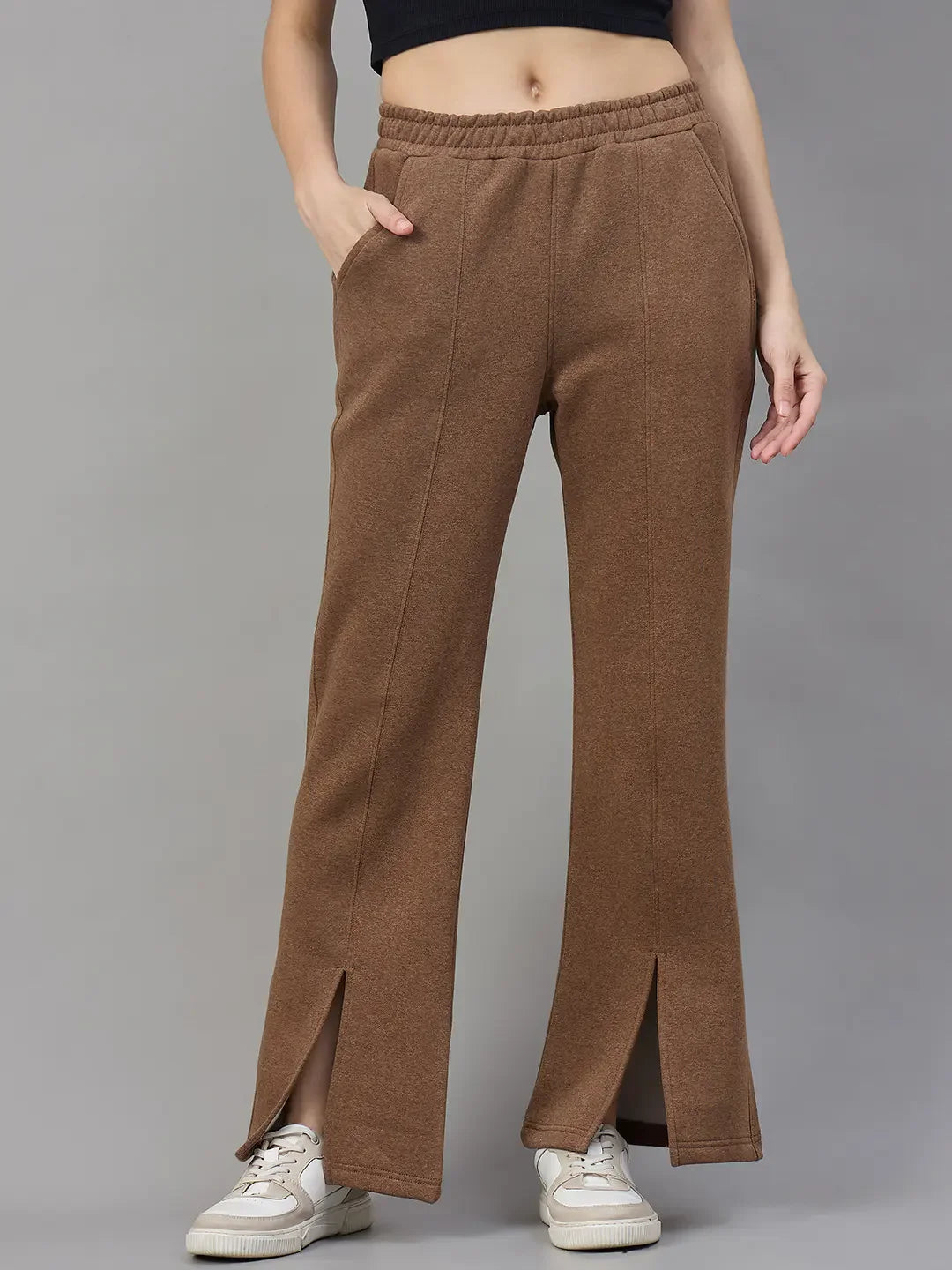 Woman wears 98degreenorth Coffee Melange Fleece Bootcut Sweatpants, white sneakers, and a black crop top.