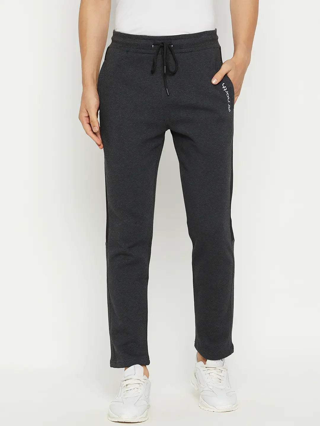 Man models 98degreenorth Men’s Anthra Fleece Trackpants with Side Stripe, styled with white sneakers on a plain backdrop.