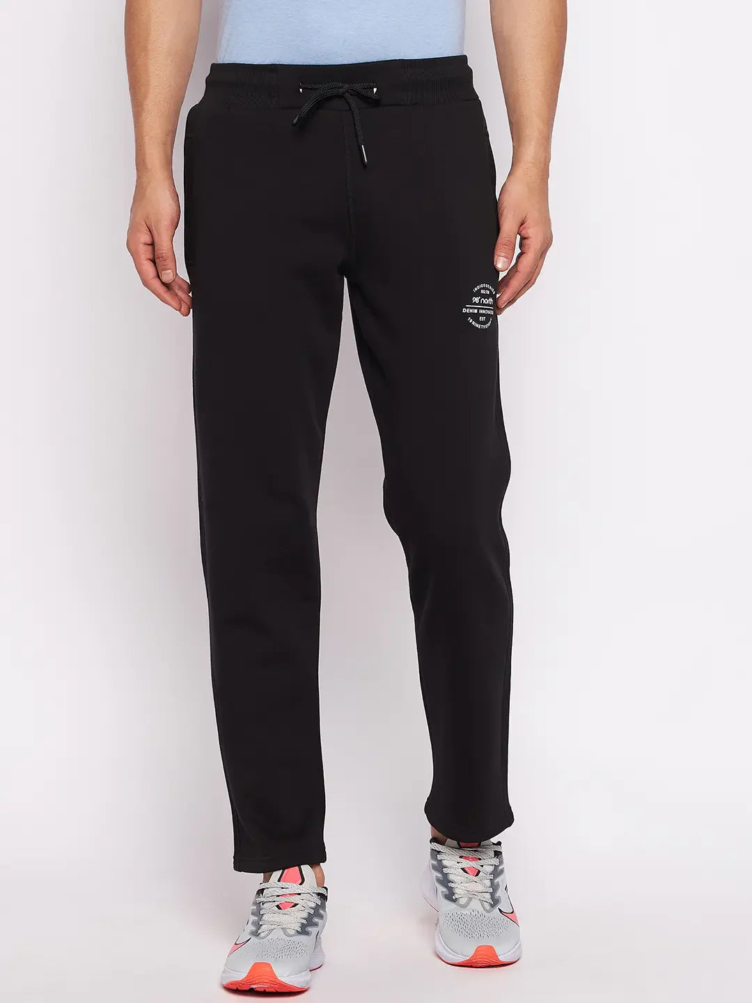 Man in 98degreenorth Men’s Black Fleece Trackpants—warm joggers with ribbed waistband—paired with gray-pink shoes.