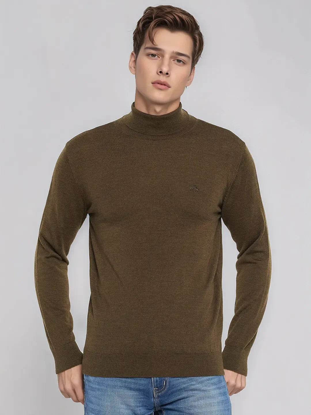 A man in a 98degreenorth Coffee Merino Wool Turtle Neck Sweater and blue jeans stands against a light gray background.