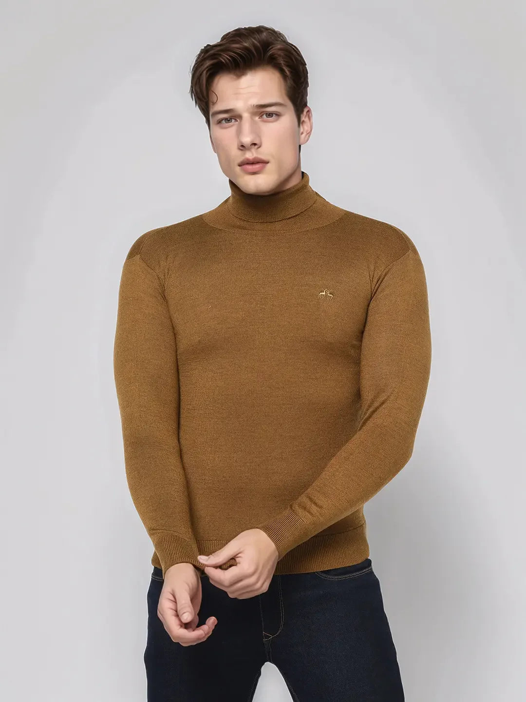 A man in a 98degreenorth dark khaki merino wool turtle neck sweater stands before a plain light gray background.