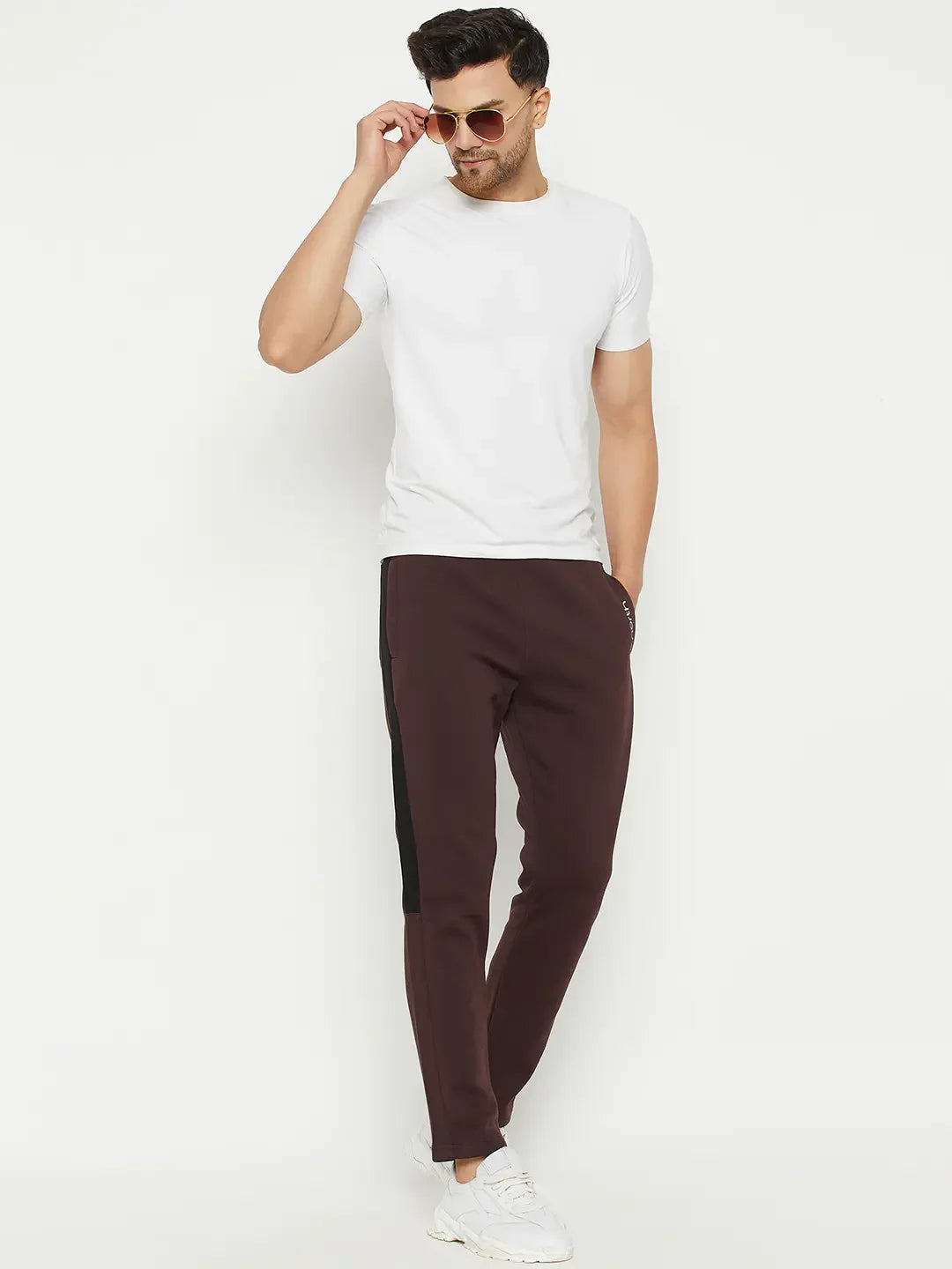 Man wearing sunglasses, a white tee, 98degreenorth Dark Wine Fleece Joggers with black stripes, and white sneakers.