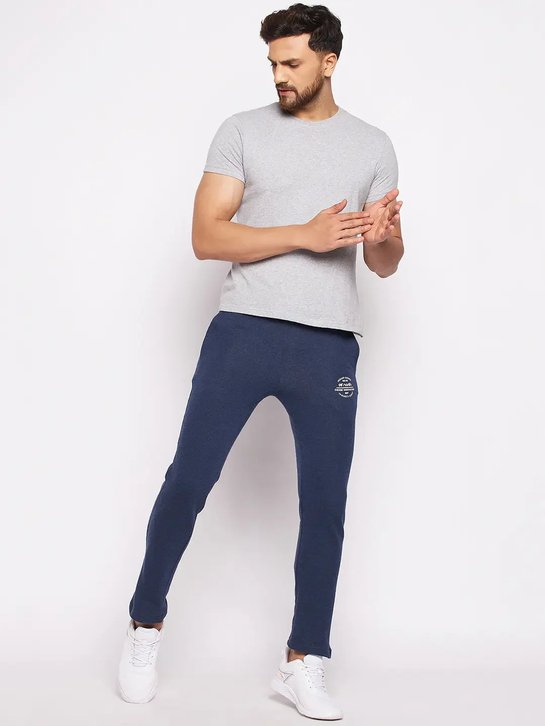 Man in 98degreenorth Men’s Denim Fleece Trackpants, grey tee, and white sneakers against a white background.