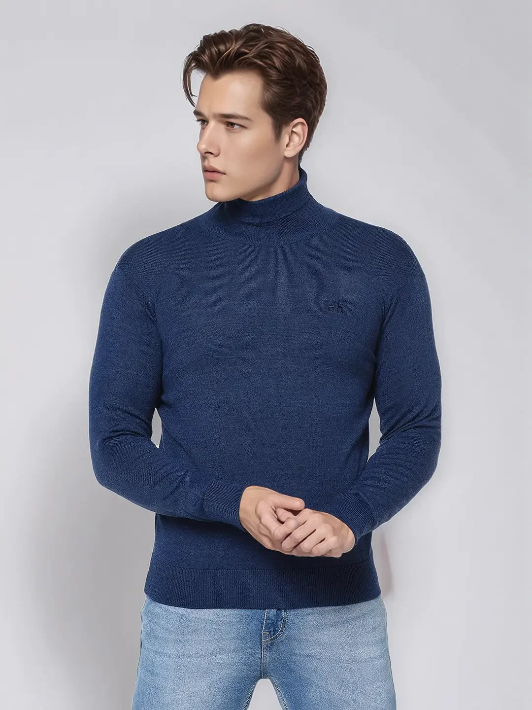 Man wearing the 98degreenorth Men’s Light Denim Merino Wool Turtle Neck Sweater in a smart-casual winter look.
