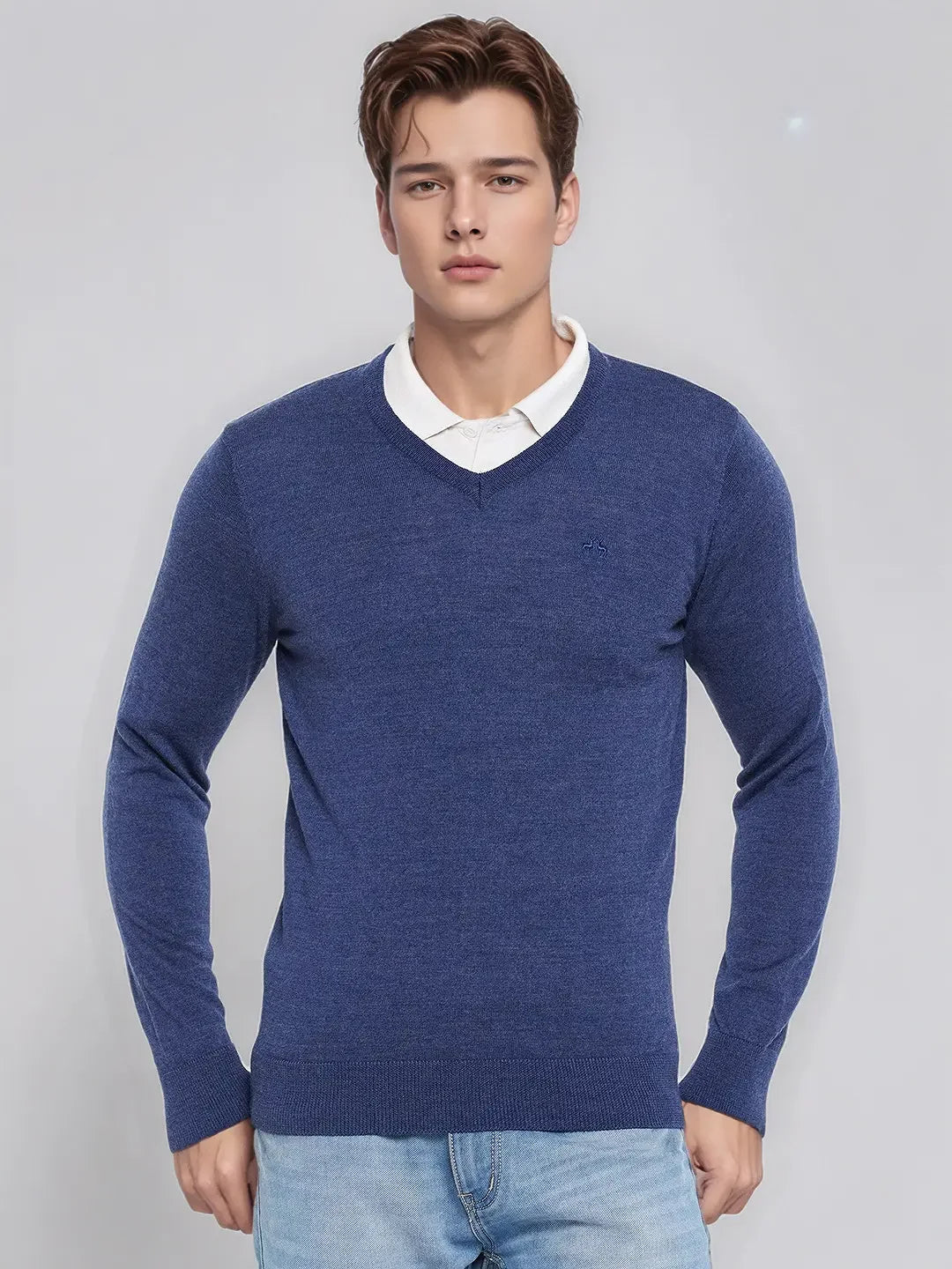Young man in 98degreenorth Men’s Light Denim Merino Wool V-Neck Sweater, over a white shirt and light blue jeans.