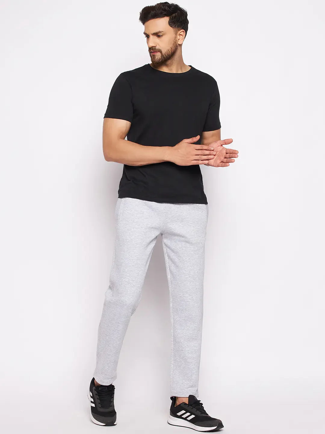Man in 98degreenorth Men’s Light Grey Fleece Trackpants and black tee, standing against a white background.