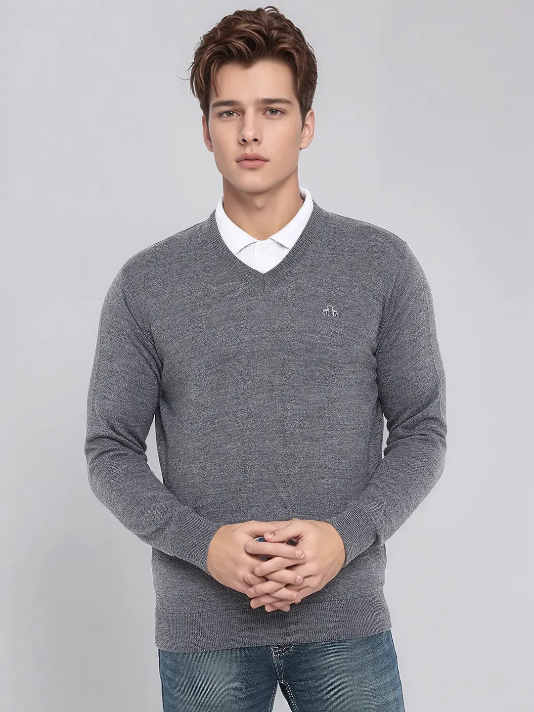Young man in a 98degreenorth Men’s Medium Grey Merino V-Neck Sweater over a white shirt, plain light background.