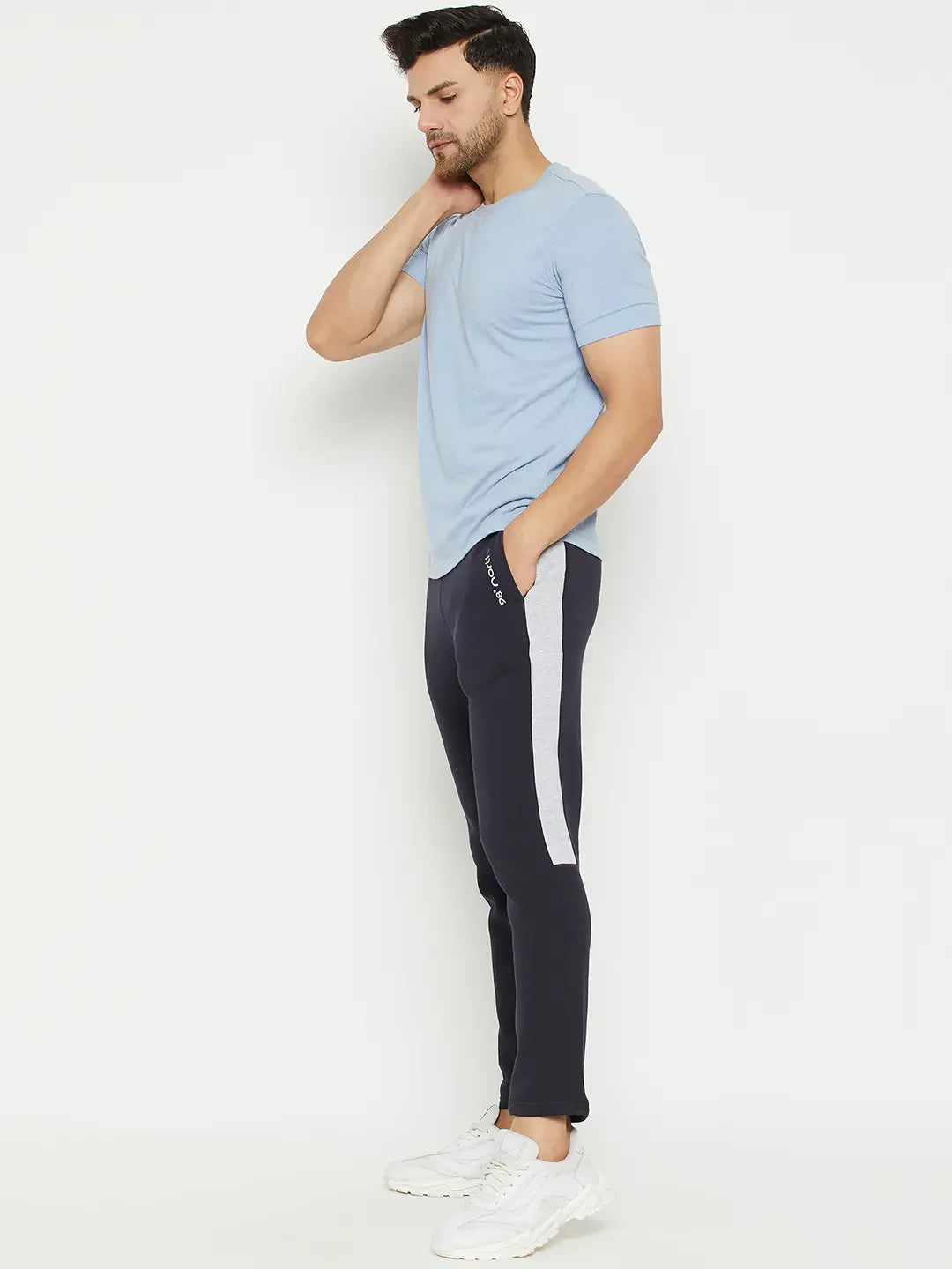 Man in a light blue tee, 98degreenorth navy fleece trackpants with contrast stripe, and white sneakers.