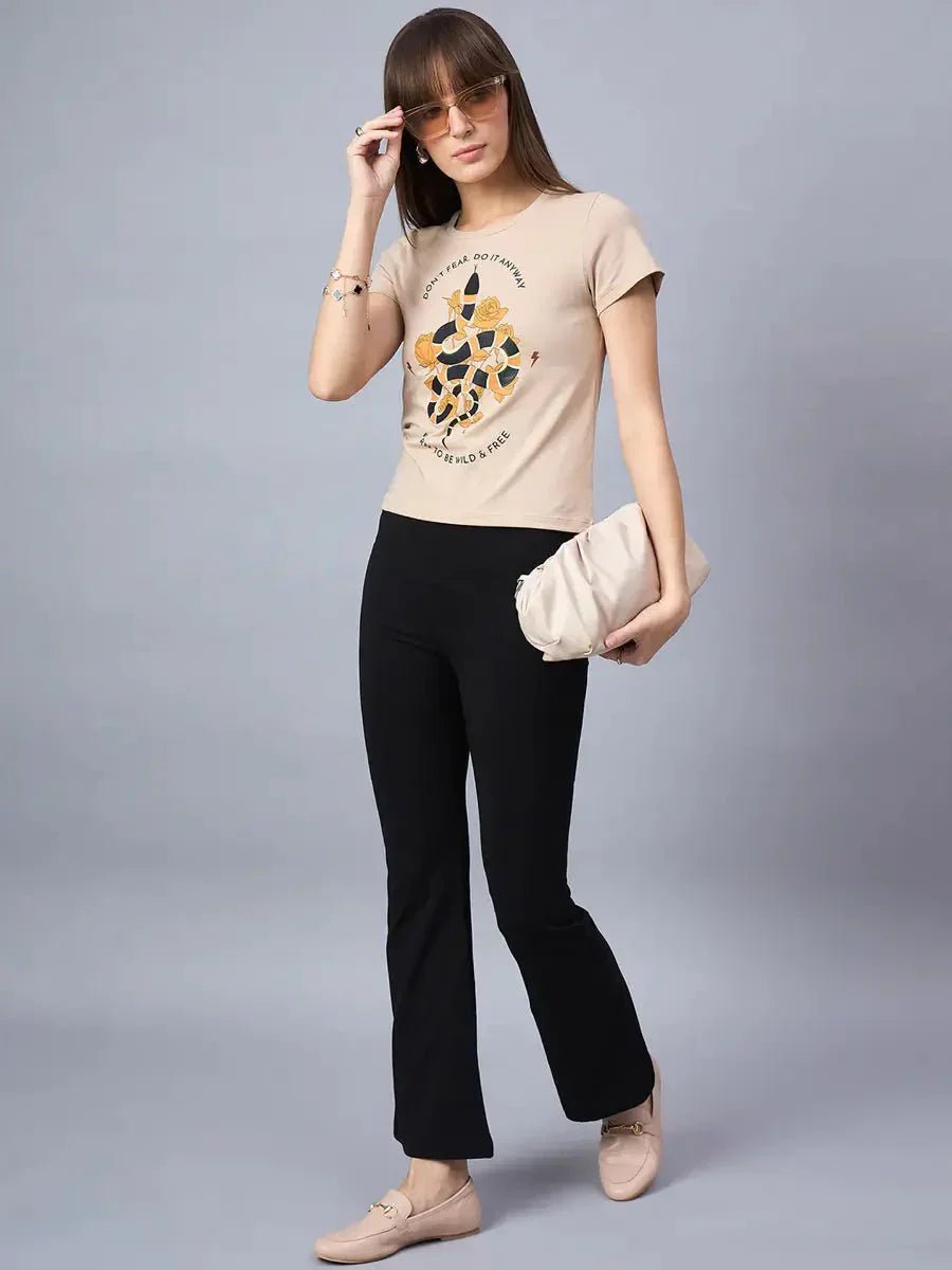 Woman in sunglasses, black pants, loafers, and 98degreenorth Minimal Typography Print Cotton Tee, holding beige clutch.