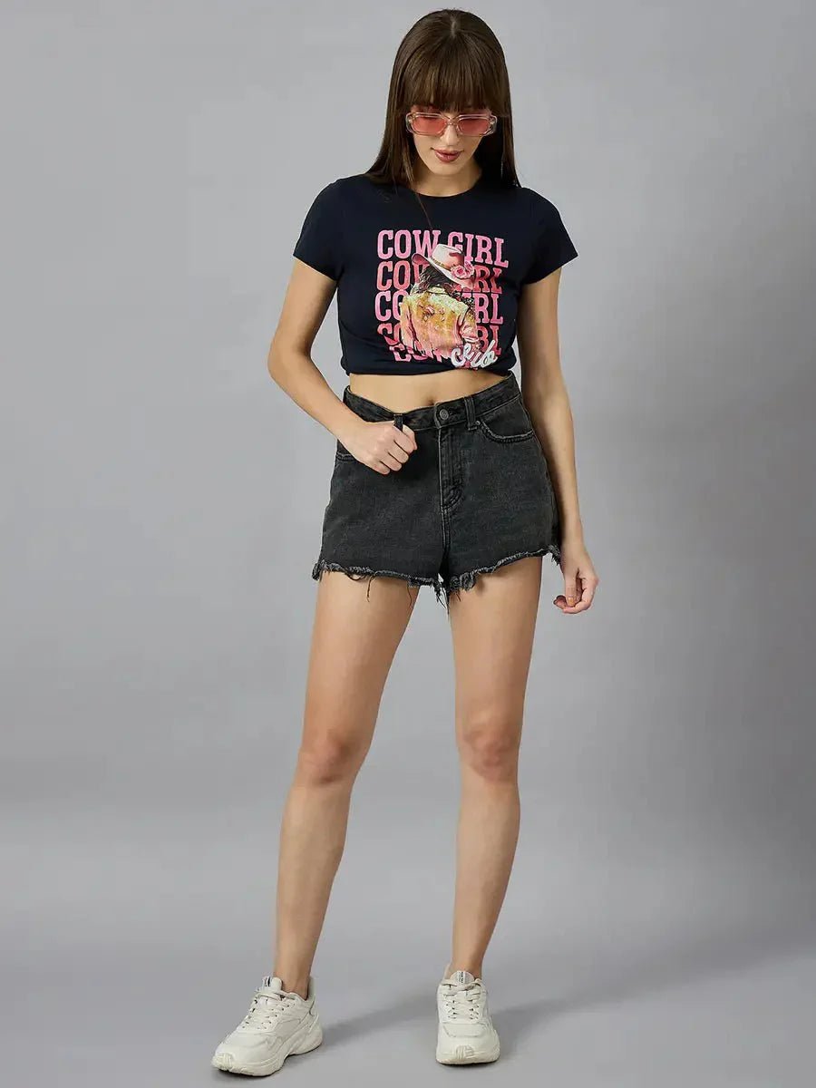 Woman in sunglasses wears a 98degreenorth Women’s casual typography t-shirt in 100% cotton, black shorts, and white sneakers.