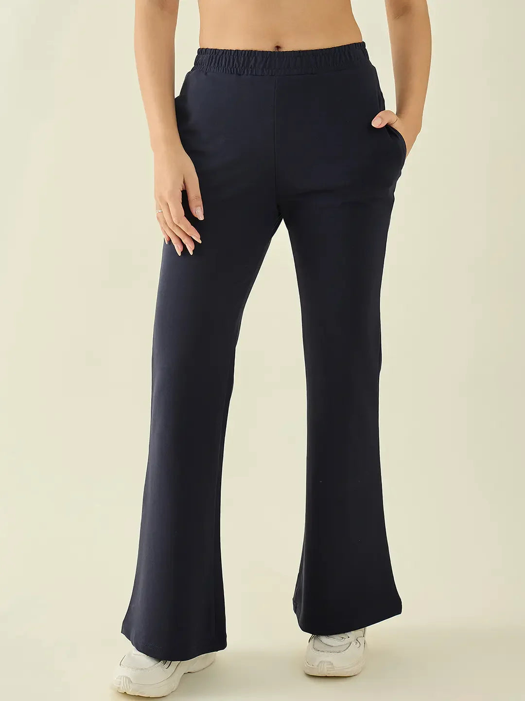 Model wears 98degreenorth Women’s Navy Flared Fit Bootcut Trousers with pockets and white sneakers, waist-down view.