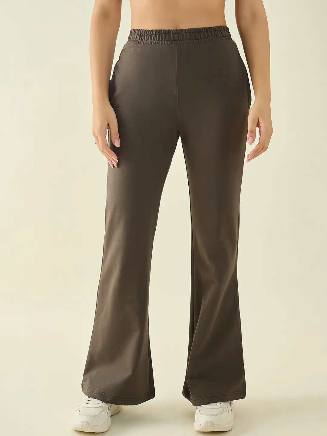 A person in 98degreenorth Women’s Olive Flared Bootcut Cotton Stretchable Trousers, waist to feet, plain background.