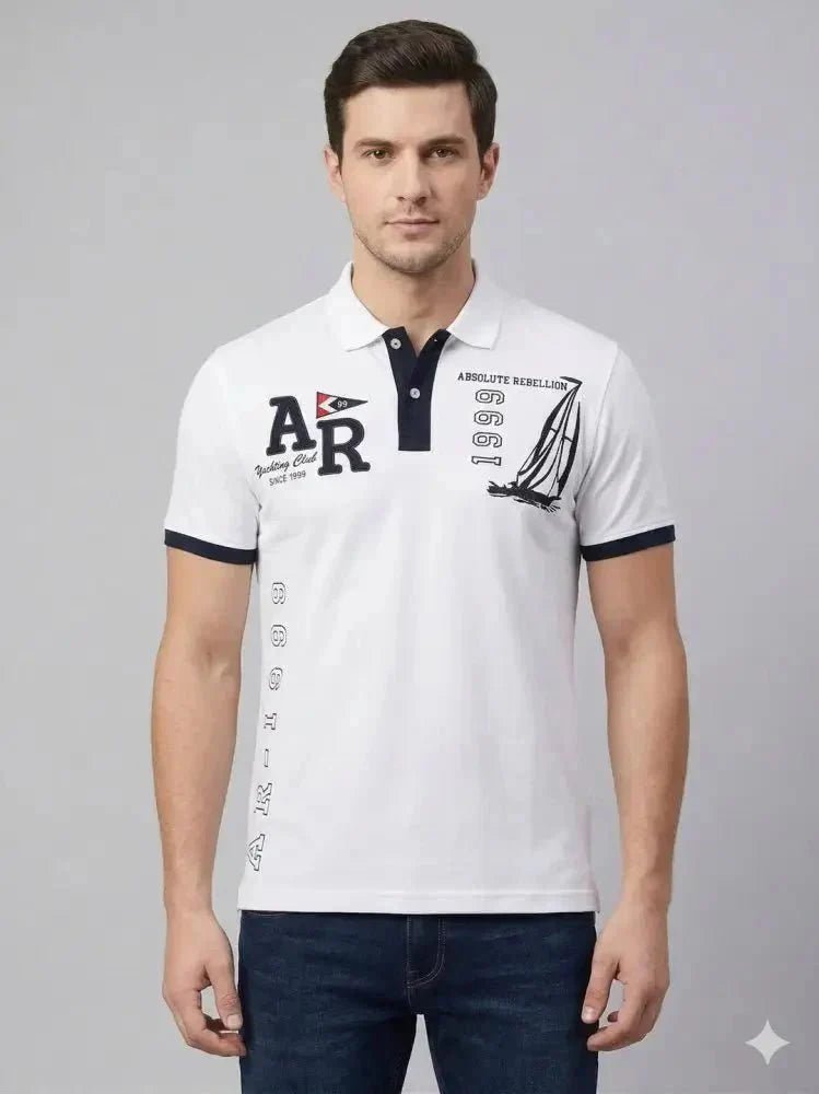 Man wearing a mustard brown short-sleeve polo shirt and light blue jeans, standing against a plain white background, looking to his left with one hand by his side.