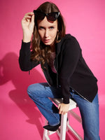Woman wears 98degreenorth Black Fleece Zipper Hoodie and blue jeans, lifting sunglasses against a pink background.