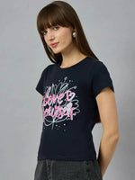 Woman with long brown hair wears a 98degreenorth must-have cotton typography t-shirt styled with pink and white text.