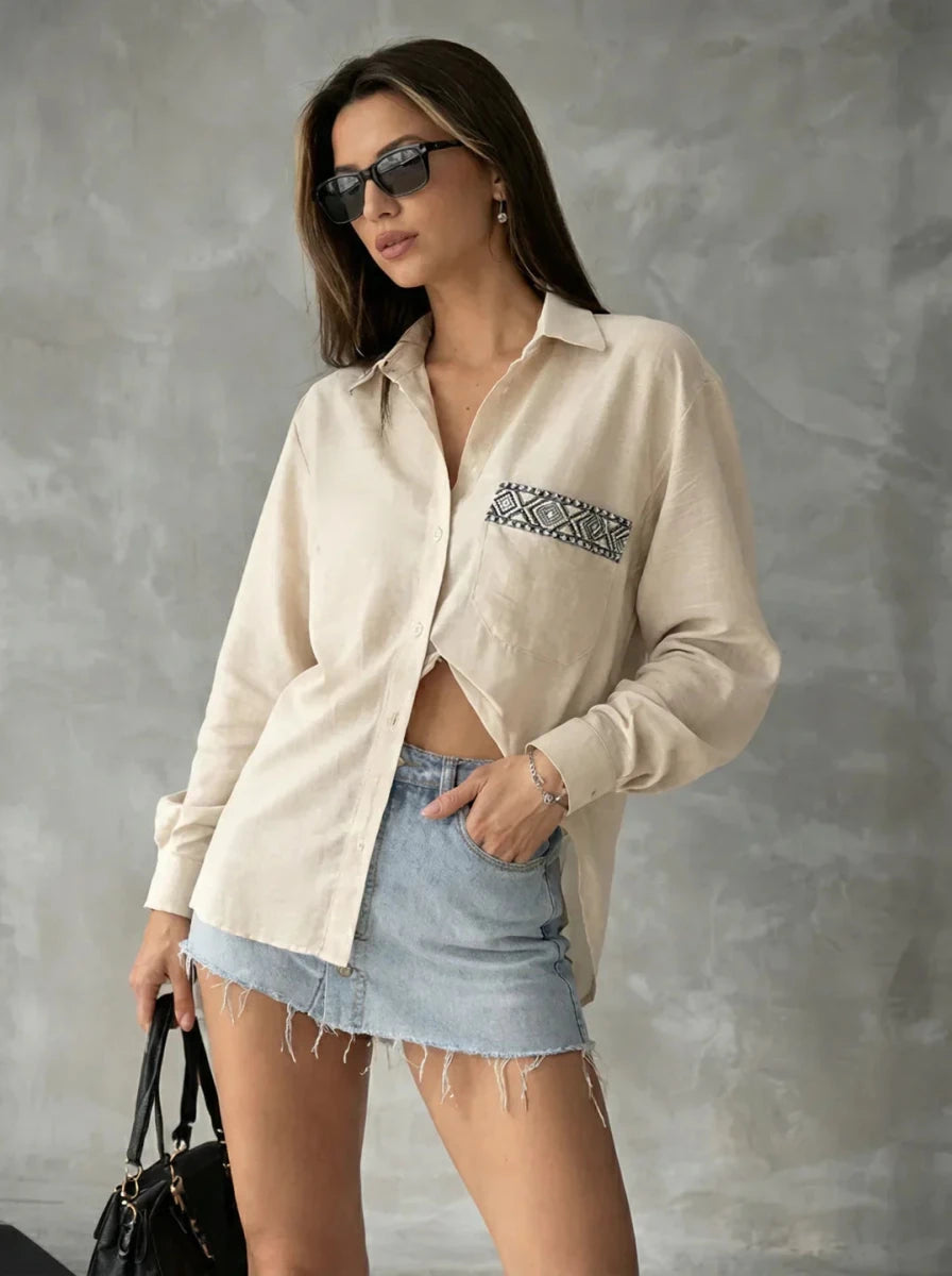 Woman in sunglasses, 98degreenorth Beige Aztec Embroidered Pocket Cotton Shirt, and a frayed denim mini skirt.