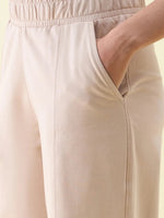 Close-up of a person in 98degreenorth’s Beige Wide Leg Pintuck Trackpants, showing texture and relaxed fit.