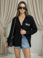 Woman in sunglasses wears 98degreenorth's Black Aztec Embroidered Pocket Cotton Shirt, denim shorts, and a black purse.