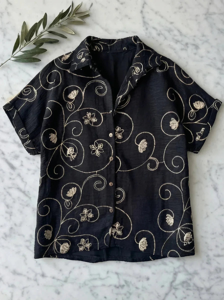 98degreenorth Black Floral Embroidered Linen Shirt—luxury summer style with gold botanical details on marble backdrop.