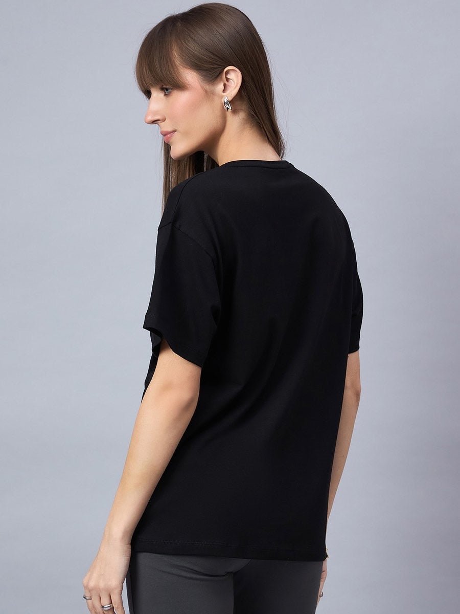 Woman with long brown hair wears a 98degreenorth Black Typography Printed Oversized Cotton T-shirt, facing away.