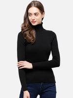 Woman in a 98degreenorth black ribbed turtleneck sweater and blue jeans, standing against a plain background.