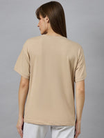 Woman with straight brown hair wears 98degreenorth’s beige Casual Cotton Round Neck T-shirt with Drop Shoulder Sleeves, back view.
