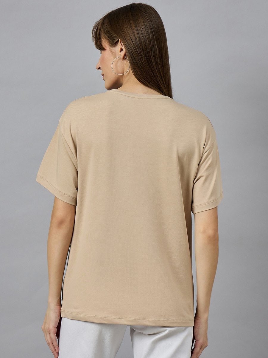 Woman with straight brown hair wears 98degreenorth’s beige Casual Cotton Round Neck T-shirt with Drop Shoulder Sleeves, back view.