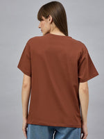 A woman wears the 98degreenorth Casual Typography Print Cotton T-shirt, showcasing effortless street style.