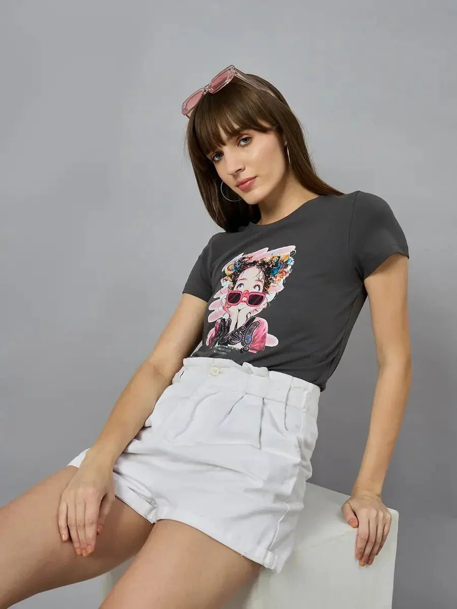 A woman wears a 98degreenorth classic round-neck typography cotton tee and white shorts, seated against a gray backdrop.