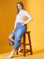 A woman models the 98degreenorth Classic White Ribbed Turtleneck Sweater against a yellow background.
