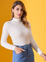 Woman in a 98degreenorth classic white ribbed turtleneck sweater and blue jeans smiles against a yellow background.