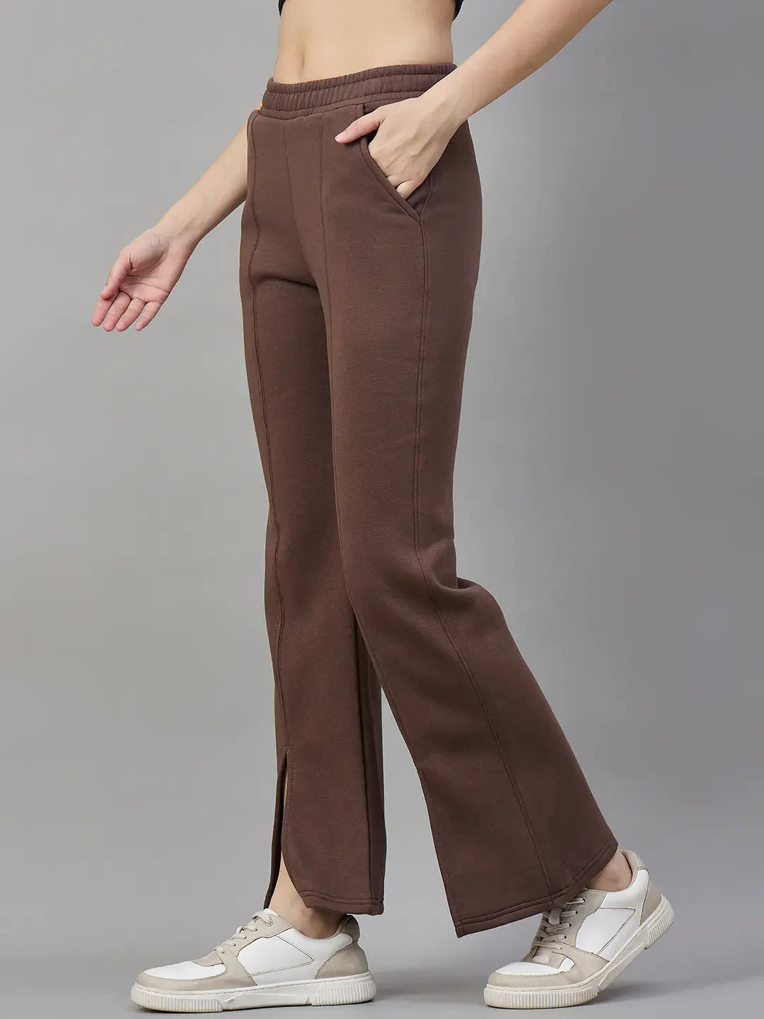 A person wears 98degreenorth Cocoa Brown Women’s Fleece Flared Sweatpants with front slits and a black crop top.
