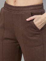 Wearing 98degreenorth Cocoa Brown Women’s Fleece Flared Sweatpants, she puts her right hand in the side pocket.