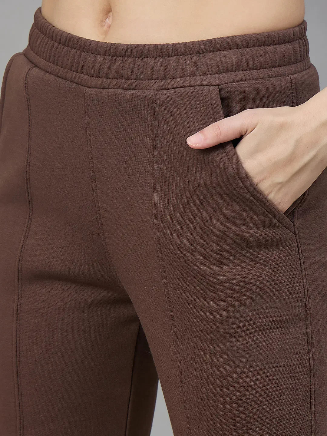 Wearing 98degreenorth Cocoa Brown Women’s Fleece Flared Sweatpants, she puts her right hand in the side pocket.