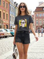 A woman in sunglasses wears a 98degreenorth Cotton Typography Print Round Neck T-shirt, strolling a city street.