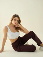 Woman wears 98degreenorth Dark Wine Fleece Flared Bootcut Sweatpants, sitting on floor in sunglasses, neutral background.