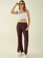 Woman wears 98degreenorth Dark Wine Fleece Flared Sweatpants with a white crop top and sneakers, posing in sunglasses.