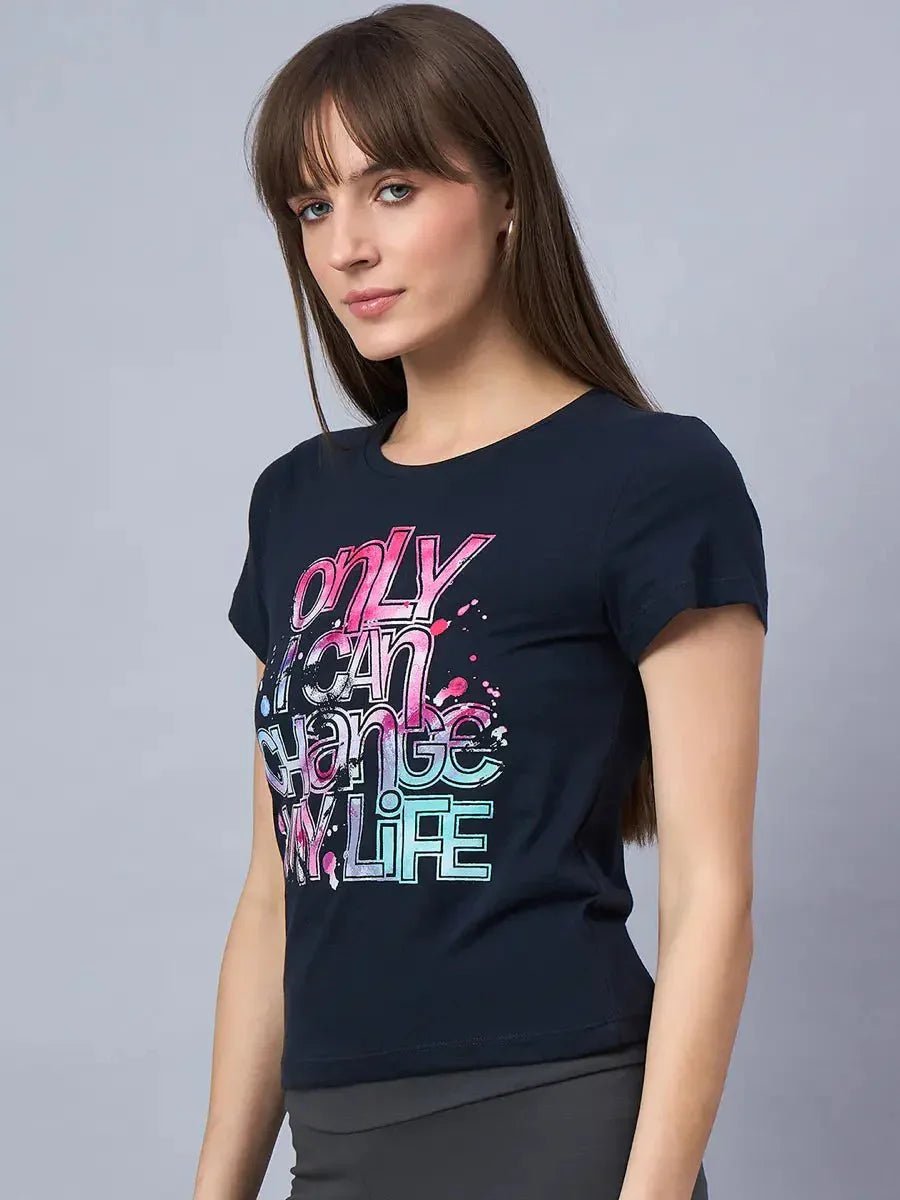 Woman in 98degreenorths soft cotton typography t-shirt, a daily essential, stands against a gray background.