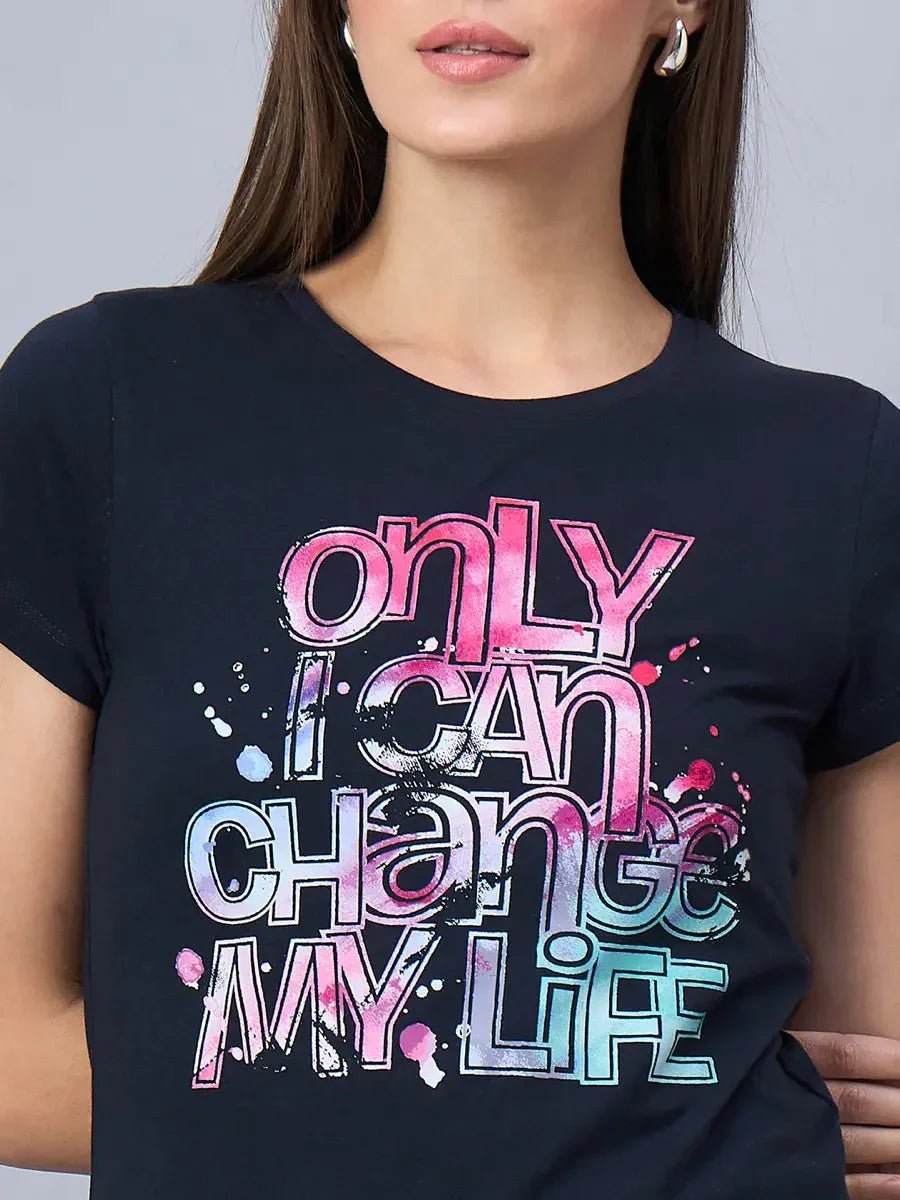 A woman wears a 98degreenorth soft cotton t-shirt with only I can change my life in bold, colorful letters.