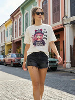 A woman in black shorts walks on a street, wearing the 98degreenorth Everyday Cotton Typography Print Tee.