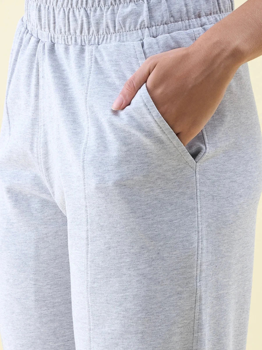 Close-up of a person wearing 98degreenorth Light Grey Wide Leg Pintuck Trackpants from the Luxe Lounge collection.