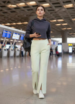 A woman in a hoodie, 98degreenorth Light Pista Women’s Fleece Flared Sweatpants, and sneakers walks through an airport.
