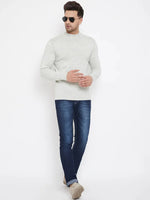 A man in dark sunglasses wears the 98degreenorth Men Merino Wool Ecru Turtleneck Pullover with blue jeans and beige shoes, posing against a plain white background with relaxed arms and one leg crossed in front of the other.