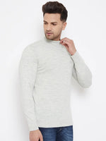 A man wears the 98degreenorth Men Merino Wool Ecru Turtleneck Pullover with blue jeans, standing against a white background, his head turned slightly to the side and one hand touching the collar.