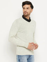 Man wears a 98degreenorth Men Merino Wool Ecru V-Neck Pullover over a black shirt and blue jeans, on a white background.